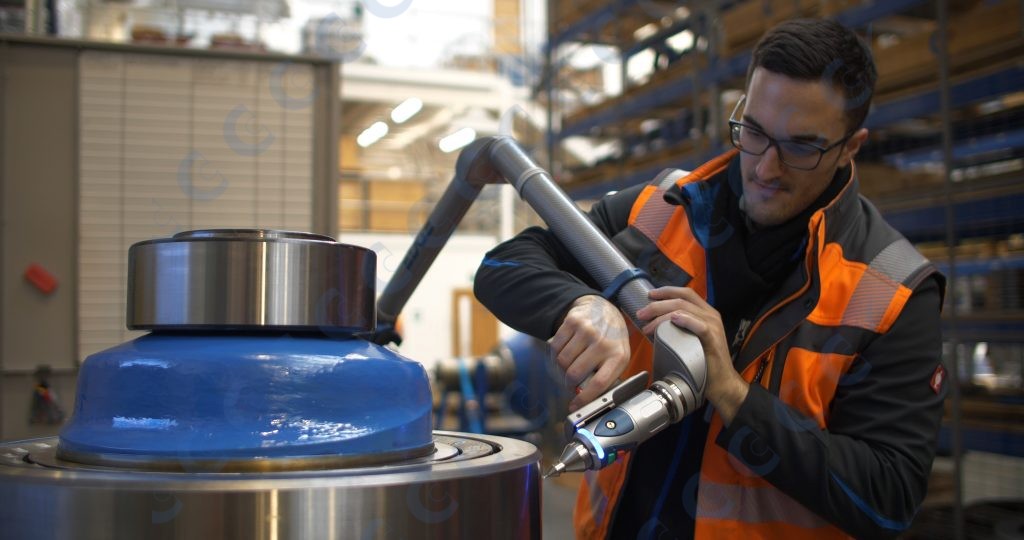 A man in a high visibility jacket working on a piece of machinery